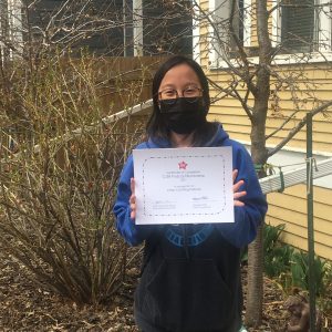 Gaywire contributor Ash Halinda holds up a Podcast Bootcamp graduation certificate