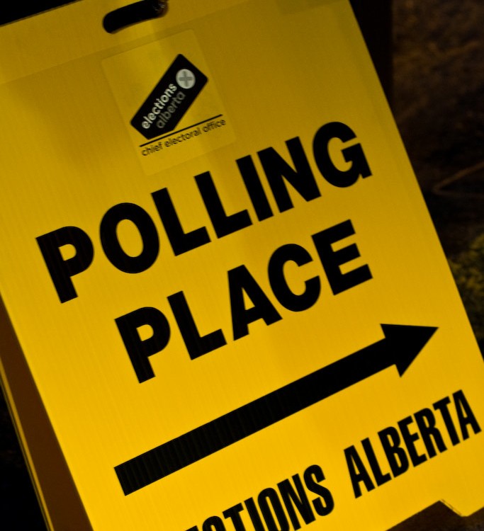 A yellow sign points to an Elections Alberta polling place