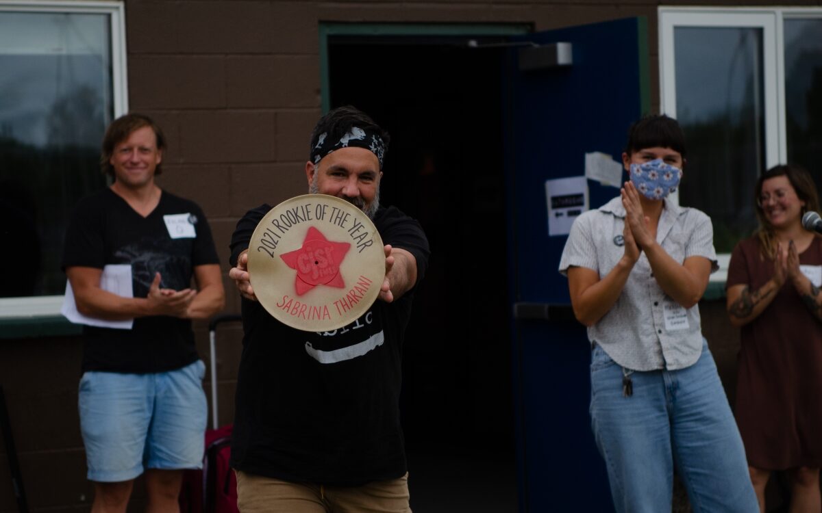 russ cobb holds up a golden record awarded to sabrina tharani for rookie volunteer of the year - photo by emma hole